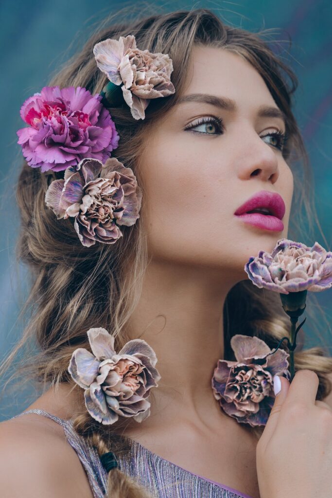 Gorgeous young woman with colorful flowers in hair